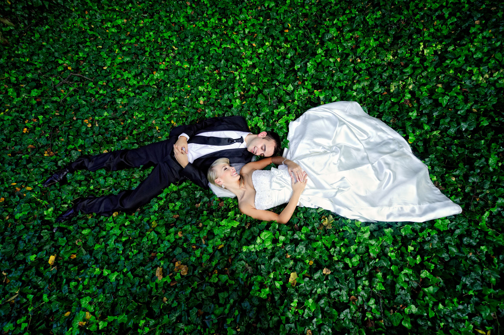 plener ślubny z parą młodą leżącą na trawie